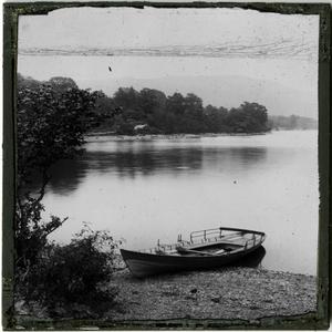 Glass Slide of Boat Beached on Mountain Lake