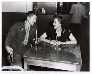 [A United States Army private and a woman in Austin's U.S.O. Club]