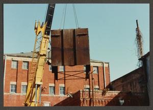 Primary view of object titled '[Crane Lifting heavy Machinery]'.