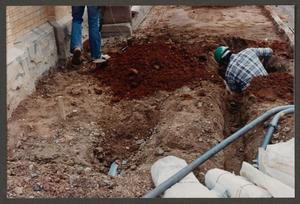 [Worker Standing in Ditch During Renovation of Dr. Pepper Museum]