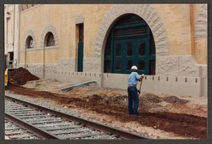 Primary view of object titled '[Worker Digging Ditch at Northwest Side of Building]'.