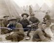 Primary view of [Group of World War I Army enlisted men eating beside tent rows]