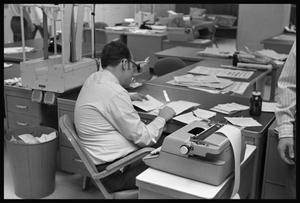 Primary view of object titled '[Man Sitting at Desk in Newsroom]'.