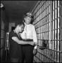 Photograph: [William J. Hoover Pointing at a Holding Cell Opening]