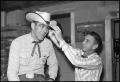 Photograph: [Benny Reynolds Tries on Cowboy Hat]