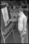 Photograph: [Boy Paints Picture on Easel]