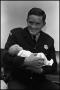 Photograph: [Patrolman Holds Rescued Baby]
