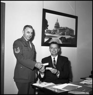 [Air Force Officer Poses With Seated Gentleman]
