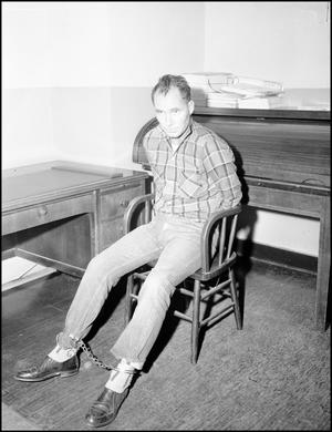 Primary view of object titled '[Reed Young Sits Handcuffed in Chair]'.