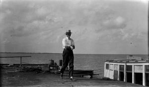 [Man with Crossed Arms Standing by a Dock]