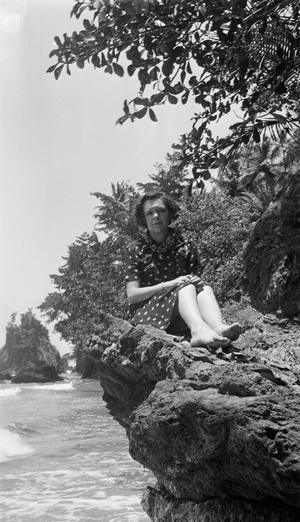 [Woman Sitting on a Rocky Outcropping by a Beach]
