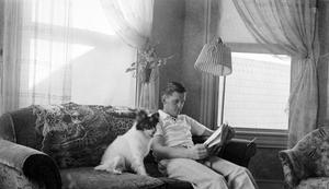 [Man Reading with a Dog]