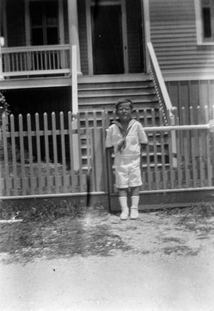 [Child Standing in Front of a Fence]