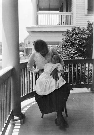 Primary view of object titled '[Woman Holding an Infant on a Porch #2]'.