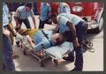 Photograph: [Paramedics Attend to Firefighter on Gurney]