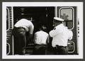Thumbnail image of item number 1 in: '[Three Paramedics Looking into an Open Ambulance]'.
