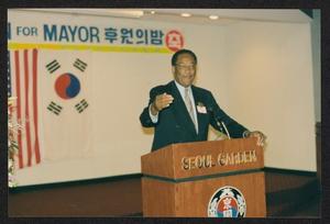 Primary view of object titled '[Photograph of Lee Brown Speaking to Houston's Korean American Community]'.