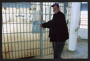 [Reginald Moore Standing Next to a Closed Gate at the Central Prison Unit]