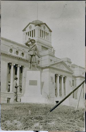 Primary view of object titled '[T. N. Carswell standing by courthouse statue in Corsicana, Texas]'.