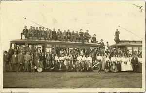 [Photograph of Simmons College personnel and students and two street cars]