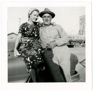 [Photo of Ed Hildebrand sitting on an automobile with unknown woman]