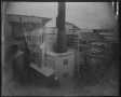 Photograph: [An exterior view of Imperial Sugar Company, a smokestack in the cent…