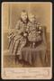 Photograph: [Portrait of Two Unknown Children With an Armchair]