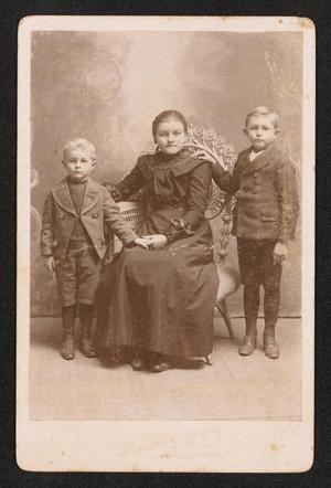 [Portrait of Three Unknown Children with a Wicker Chair]
