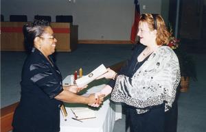 Jennifer Gayle Jones receives her certificate of membership in Alpha Beta Gamma, assisting her is Shirley Dixon.