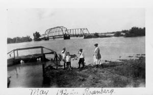 Primary view of object titled '[Four people standing near the banks of the flooded Brazos River.]'.