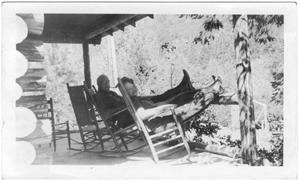 [Col. Hugh B. and Helen Moore relaxing on the porch of their ranch]