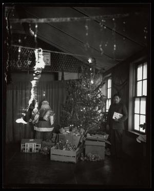 [Salvation Army Staff Member Next to Christmas Tree]