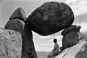 Primary view of object titled '[Two Men Sitting in a Rock Formation]'.