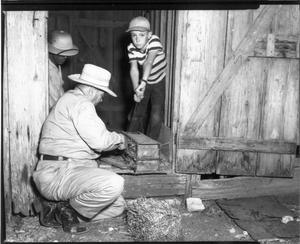 Primary view of object titled '[Men and Boy in Wooden Structure]'.
