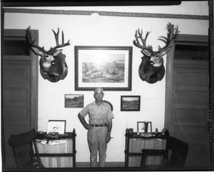 [Man Posing with Deer Heads]