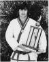Thumbnail image of item number 1 in: 'Student Showing His Karate Trophy and Medal'.