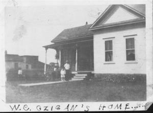 [The W.C. Czigan's Home, a man and child standing in front]