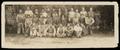 Photograph: [Group of 27 men and boys and one woman in front of a fence]