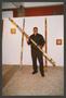 Thumbnail image of item number 1 in: '[Alonzo Davis Holding Decorated Wooden Pole]'.