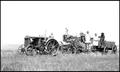 Photograph: [Tractor and combine in a grain field]