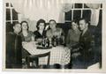 Photograph: [Geraldine Byrom & Others Sit Around a Small Table]