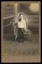 Photograph: [Portrait of an Unknown Boy Next to a Wicker Chair]
