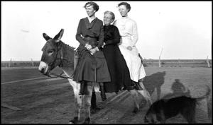 [Three women on a donkey]
