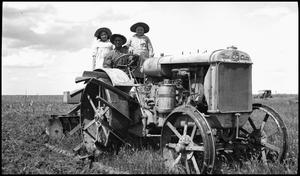 Primary view of object titled '[Man and two girls on a tractor]'.