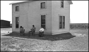Primary view of object titled '[Three people outside a farmhouse]'.
