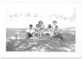 Photograph: [Hispanic Woman and Children Sitting in the Grass # 1]