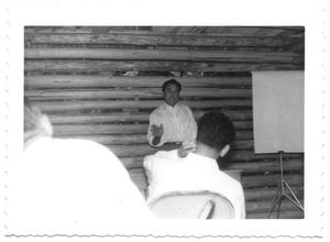 [Hispanic Man Teaching in a Log Cabin]