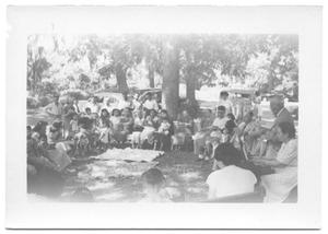 Primary view of object titled '[Group of People Sitting in a Circle Outdoors]'.