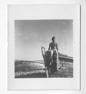 [Man Sitting on the Edge of Beached Boat]