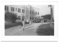 Thumbnail image of item number 1 in: '[Hispanic Woman Walking Away From a School Building]'.